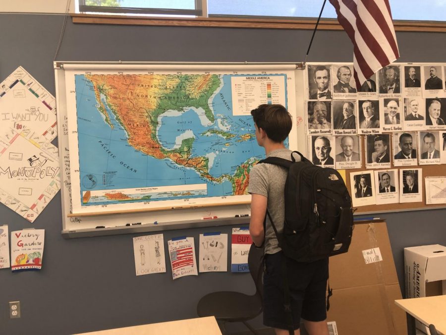 A junior examines a map in a Greylock history classroom.